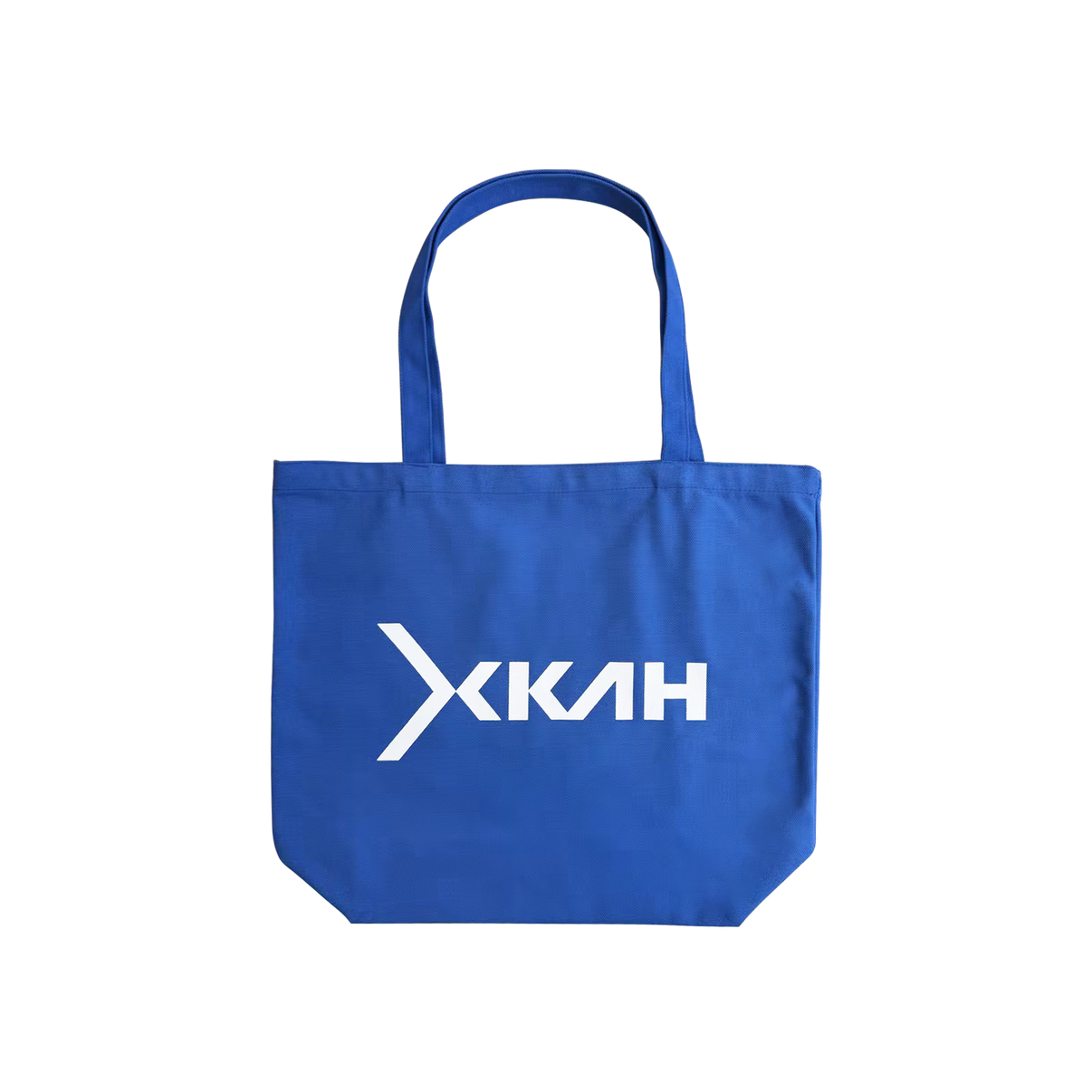 Blue tote bag with a white XKAH logo on a white background