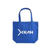 Blue tote bag with a white XKAH logo on a white background